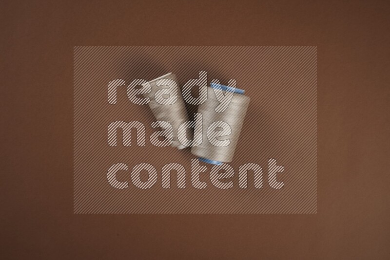 مجموعة من أدوات الخياطة والتفصيل بنية اللون على خلفية بنية