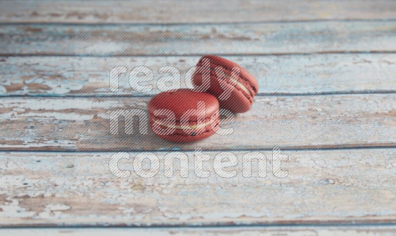 45º Shot of two Red Velvet macarons on light blue wooden background