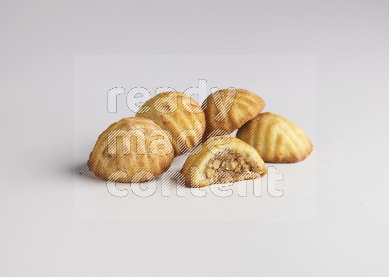 Five Pieces of Maamoul filled with walnut paste  one of them is cut with direct on white background