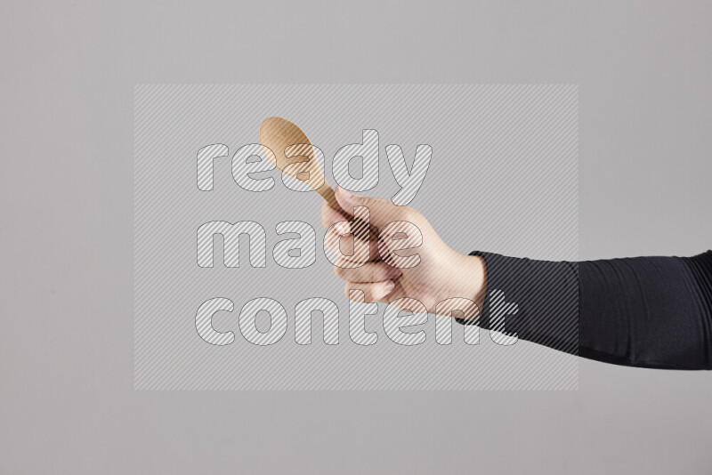 امرأة ترتدي عباءة سوداء تحمل أدوات خشبية مختلفة في أوضاع متعددة