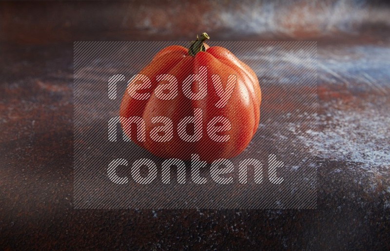 45 degree single heirloom tomato on  a textured reddish rustic metal background