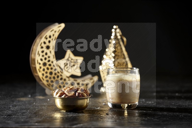 مكسرات في وعاء معدني مع مشروب التمر بجانب فوانيس ذهبية علي خلفية سوداء