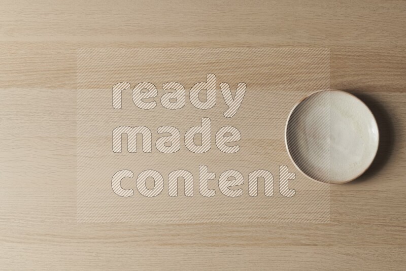 طبق من الفخار باللون البيج على خلفية خشبية فاتحة