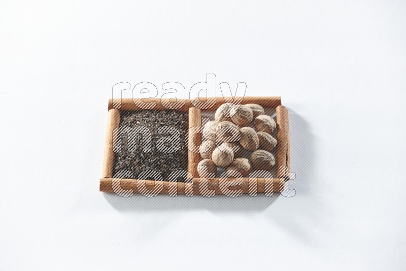2 squares of cinnamon sticks full of black tea and nutmegs on white flooring