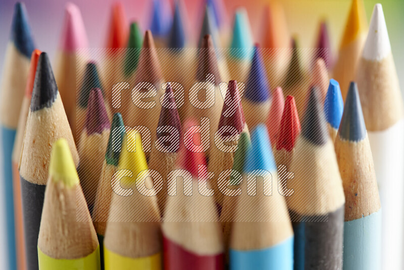 The image captures a close-up of sharpened colored pencils on multicolored background