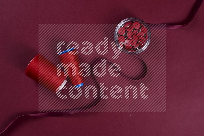 Red sewing supplies on red background