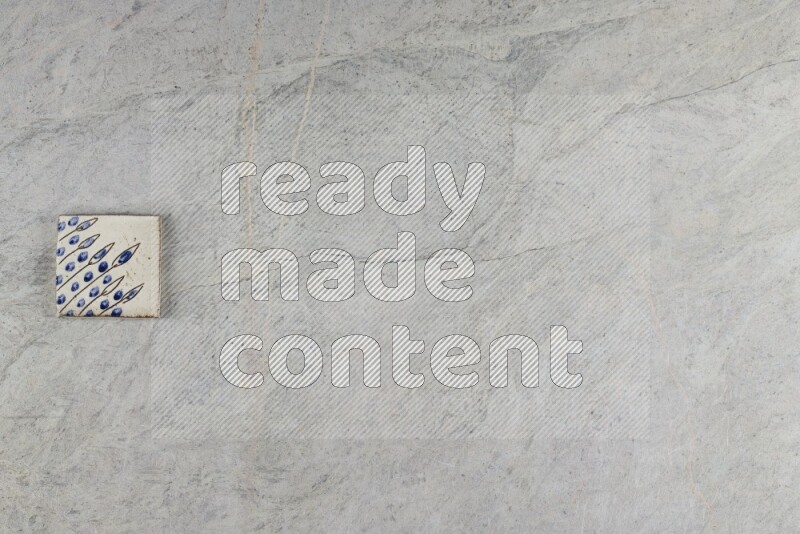 A decorative pottery coaster on grey marble background