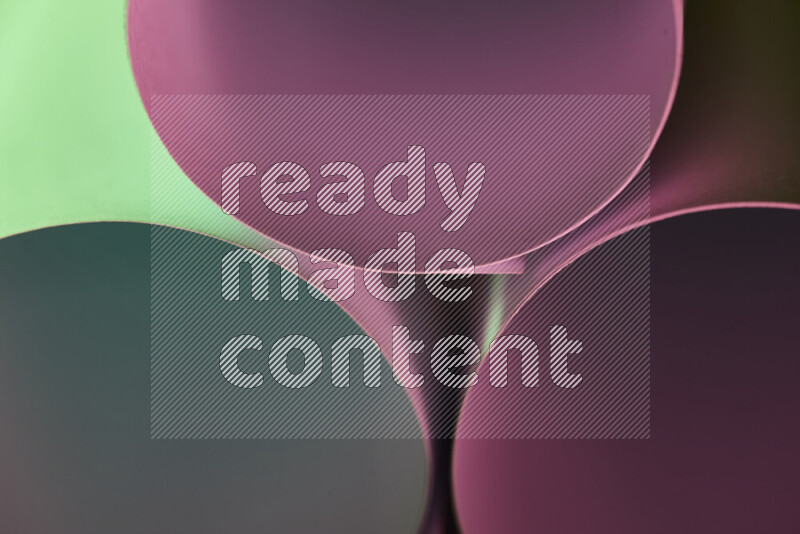 الصورة تعرض فن ورقي تجريدي بأشكال دائرية بدرجات متنوعة من اللون الأخضر والارجواني