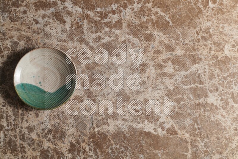 A decorative pottery plate on beige marble background