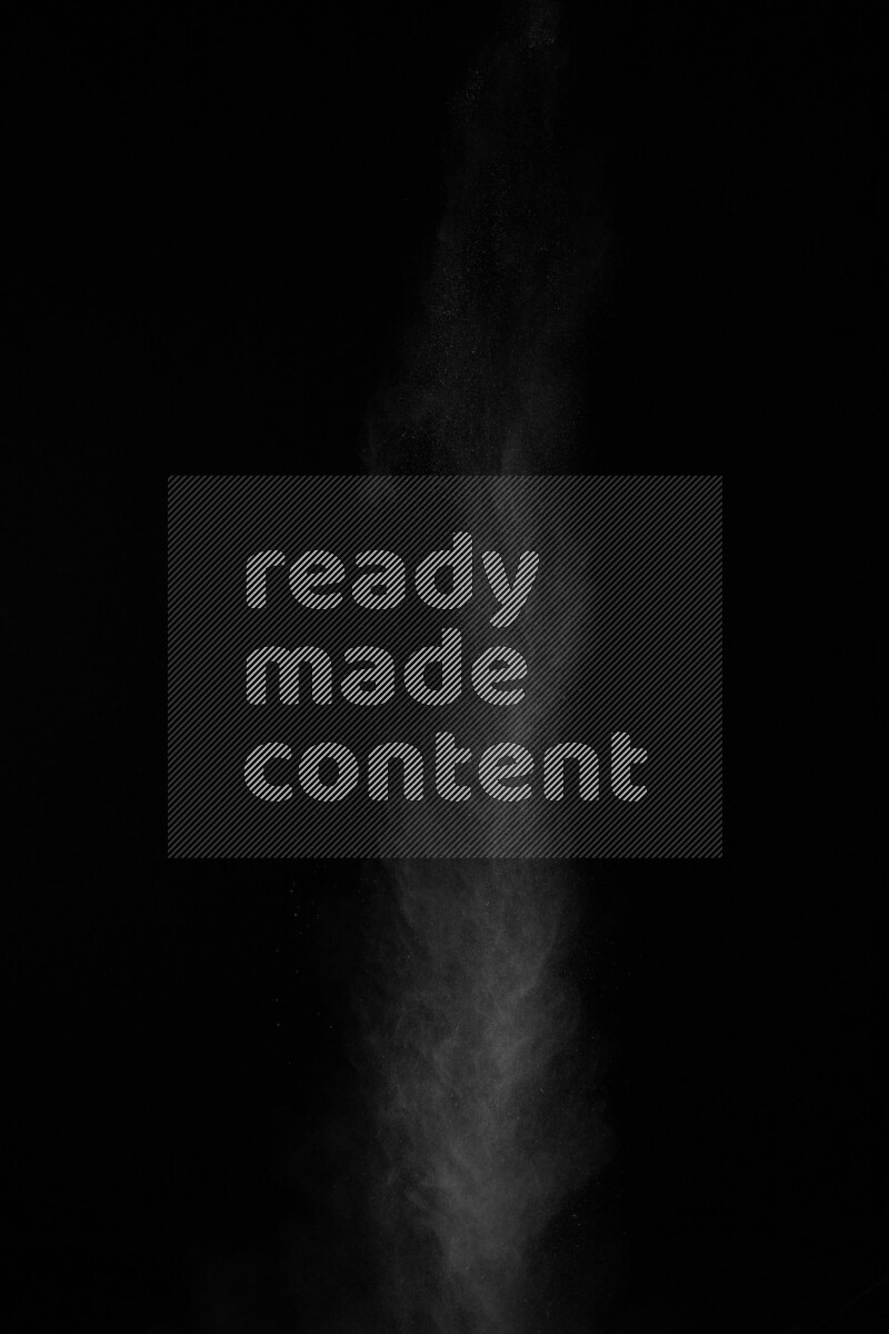 A side view of white powder explosion on black background