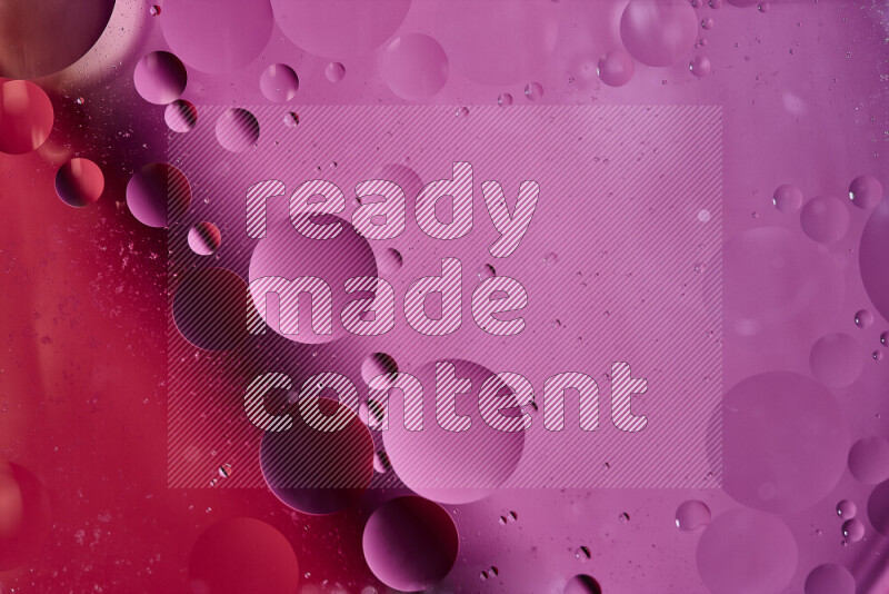 لقطات مقربة لفقاعات من الزيت على سطح الماء باللون الأحمر والوردي