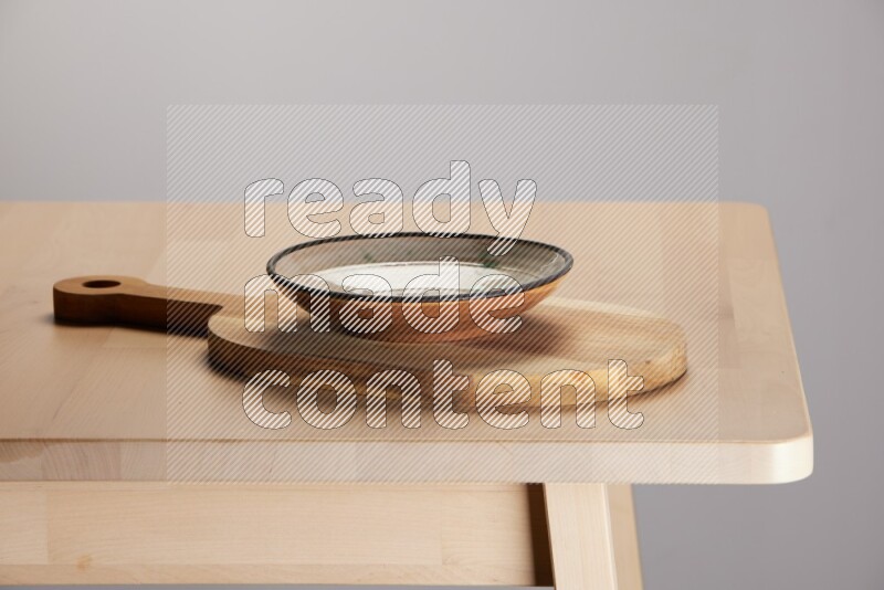 multi colored plate placed on a  wooden oval cutting board on the edge of wooden table