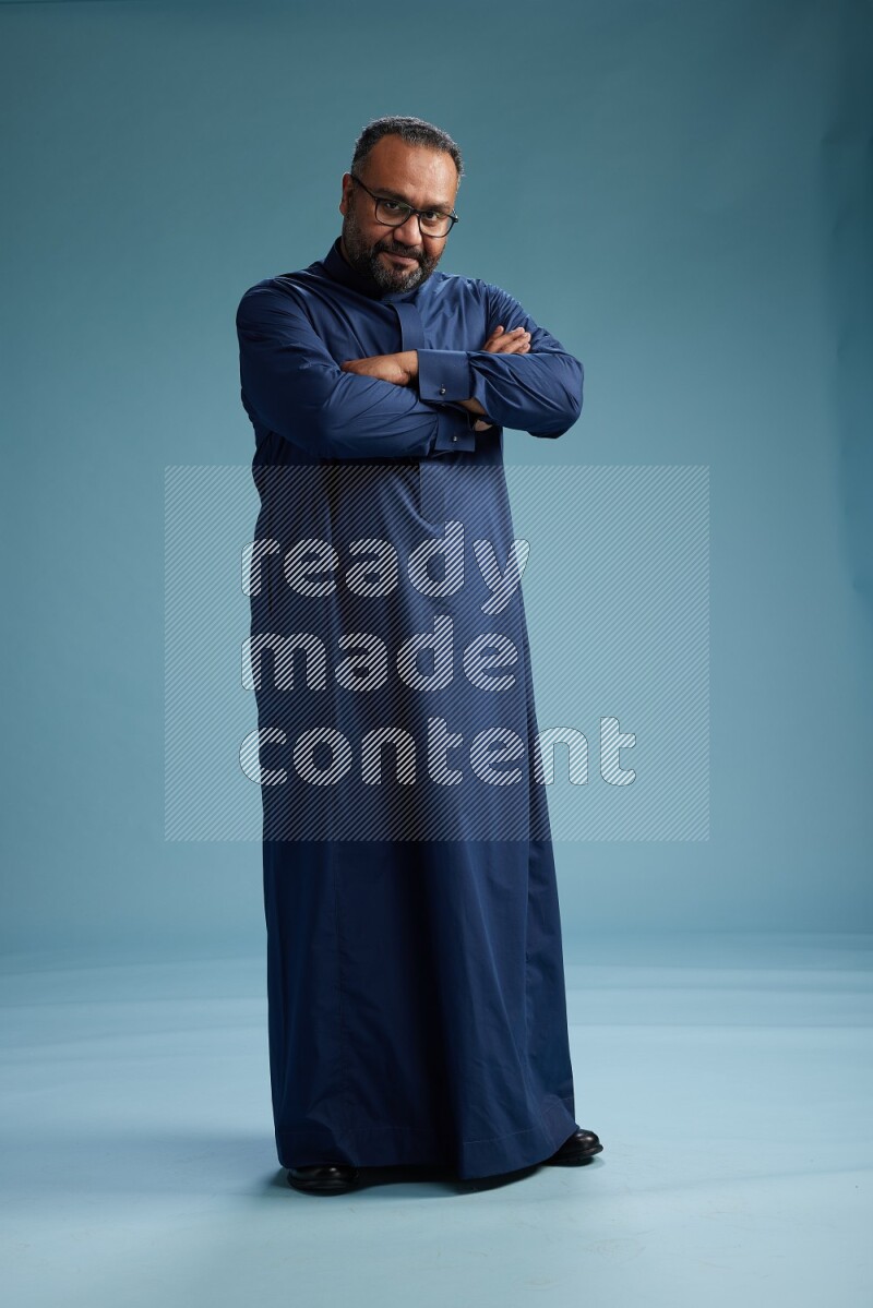Saudi Man without shimag Standing Interacting with the camera on blue background
