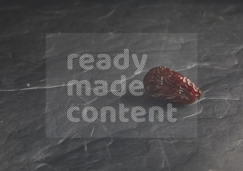 one madjoul date on a black textured background