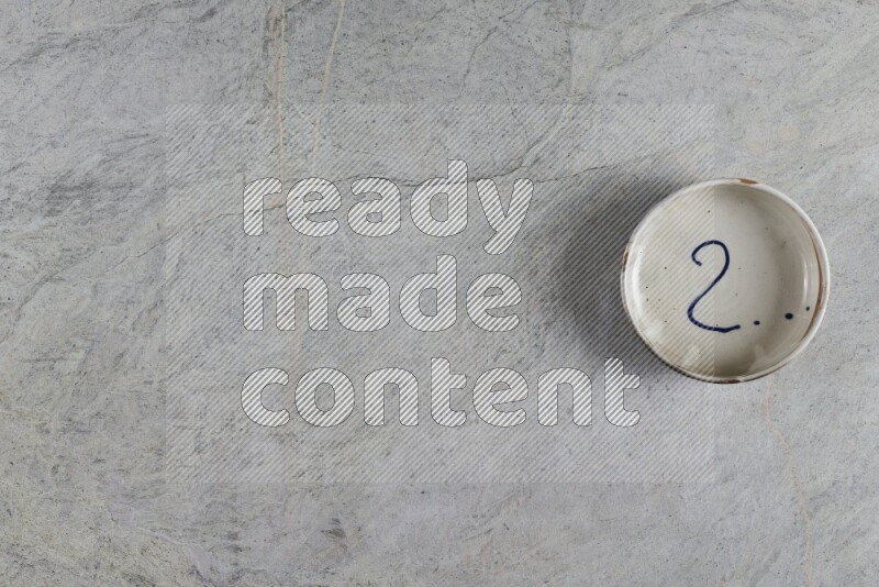 وعاء فخاري متعدد الألوان على خلفية من الرخام الرمادي