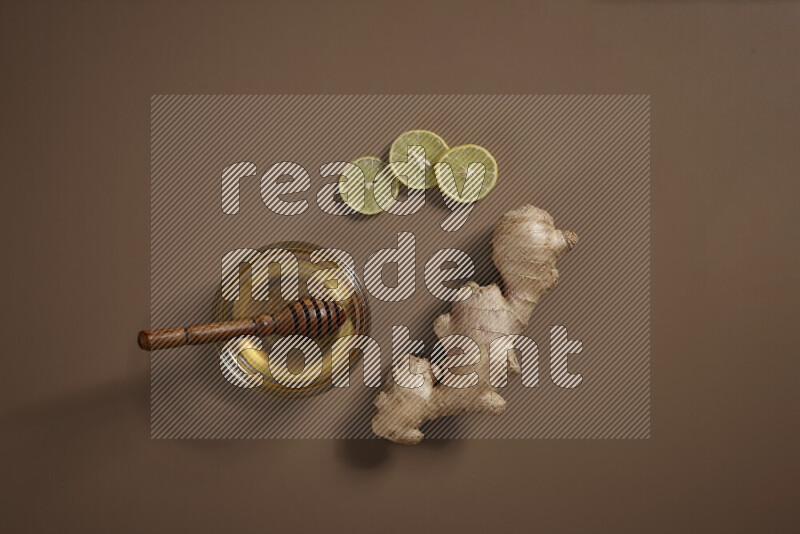 Fresh ginger root with different ingredients such as lemon, orange, honey, ground ginger on beige baackground