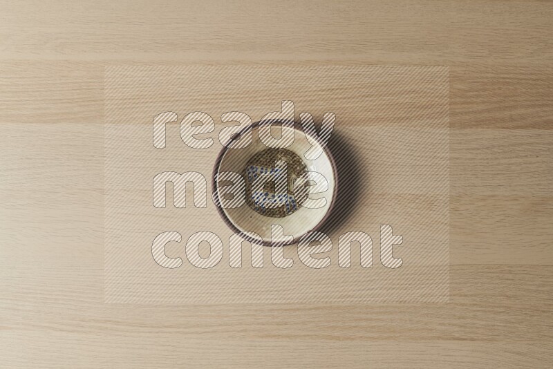 A decorative pottery plate on light wooden background