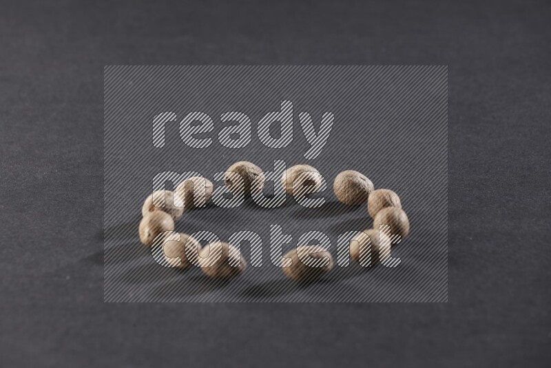 Nutmeg in a circle shape on a black flooring in different angles