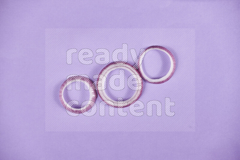 Red onions rings on purple background