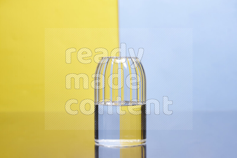 The image features a clear glassware filled with water, set against yellow and light blue background