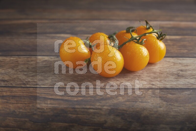 yellow cherry tomato vein on a textured wooden background 45 degree