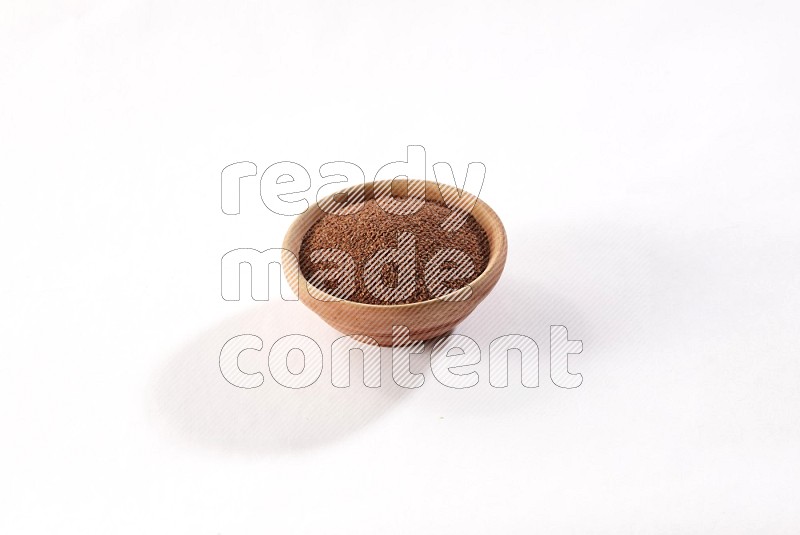 A wooden bowl full of garden cress seeds on a white flooring