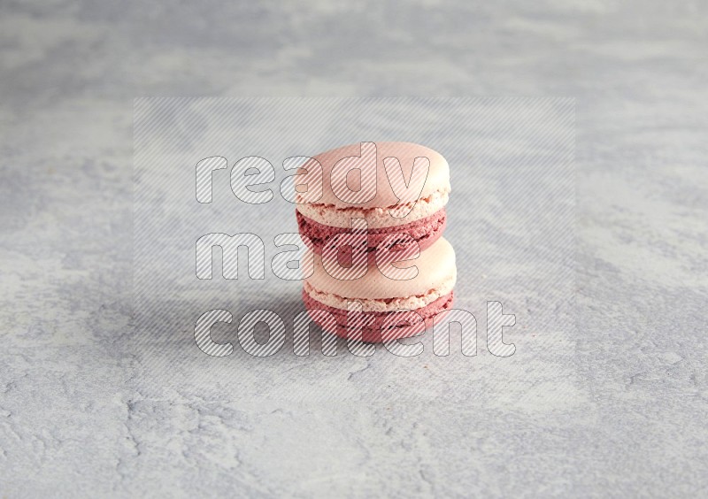 45º Shot of two Pink Litchi Raspberry macarons  on white  marble background