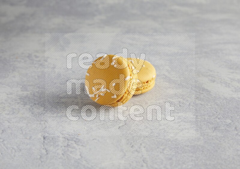 45º Shot of two Yellow Piña Colada macarons  on white  marble background