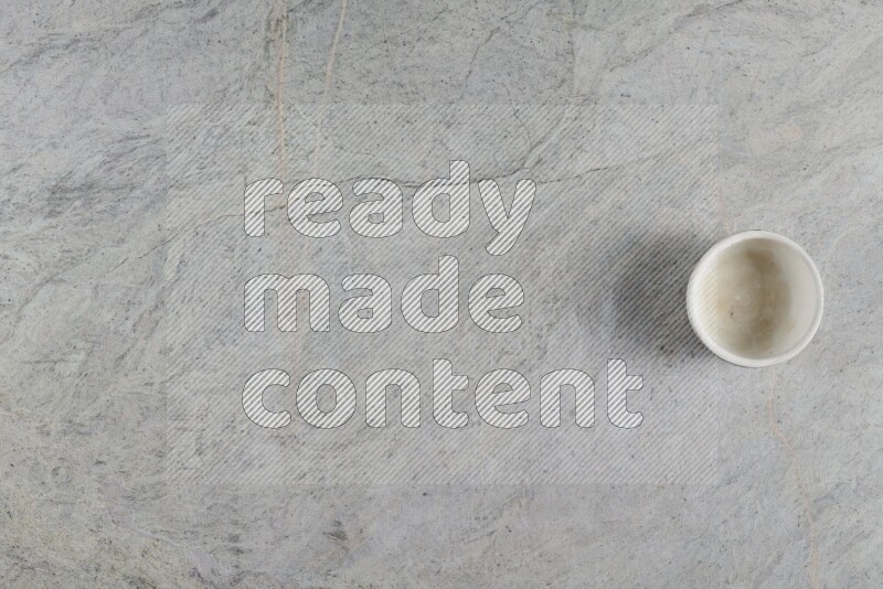 A multicolored pottery Cup on grey marble background