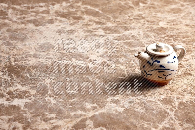 Pottery tea pot on Beige Marble Flooring, 45 degrees