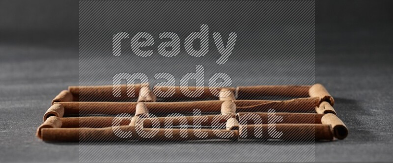 9 مربعات فارغة من أعواد القرفة على أرضية سوداء