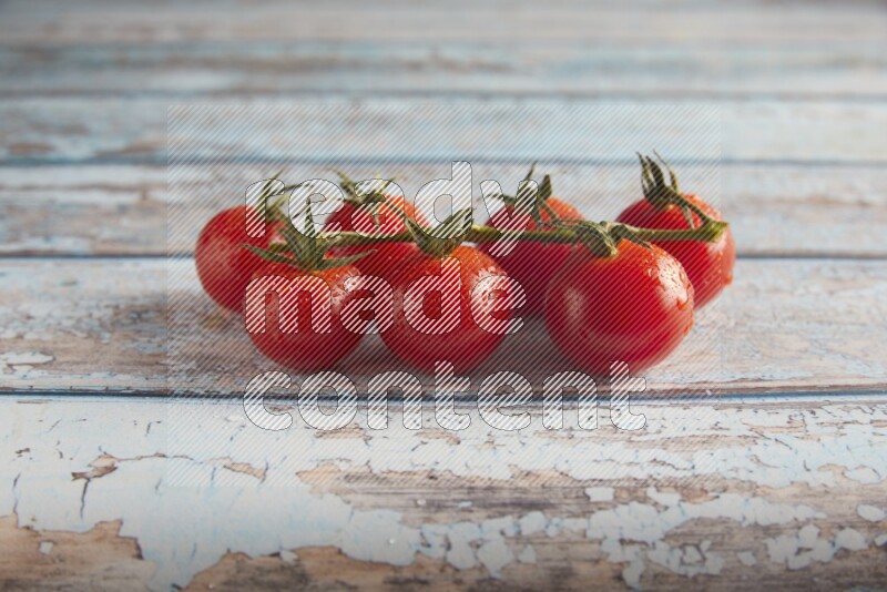 Red cherry tomato vein on a textured blue wooden background 45 degree