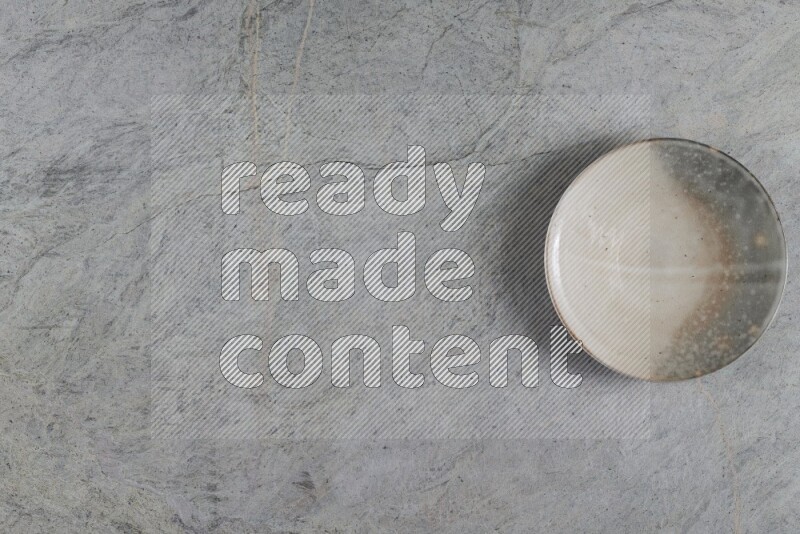 A multicolored pottery plate on grey marble background