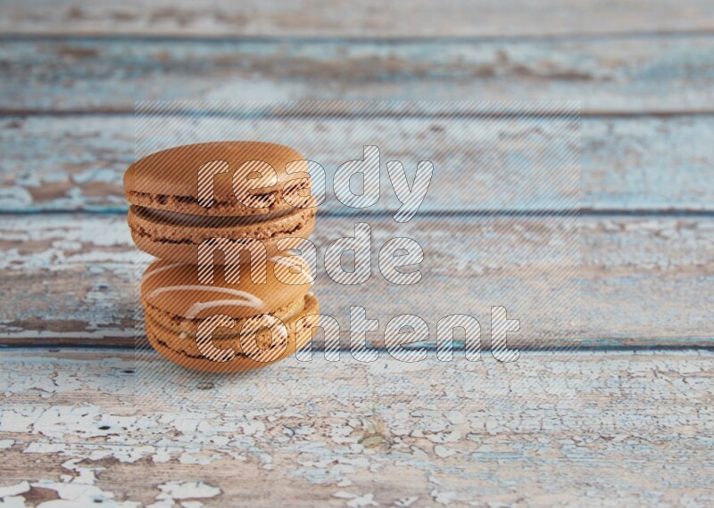 45º Shot of of two assorted Brown Irish Cream, and Brown Coffee macarons on light blue background