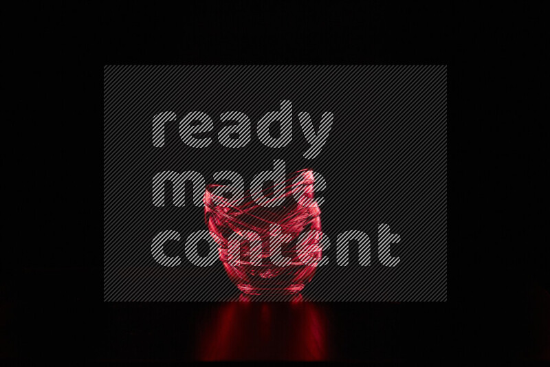 Glassware with rim light in red against black background