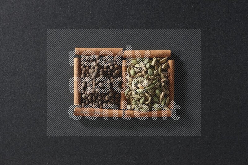 2 squares of cinnamon sticks full of allspice and cardamom on black flooring
