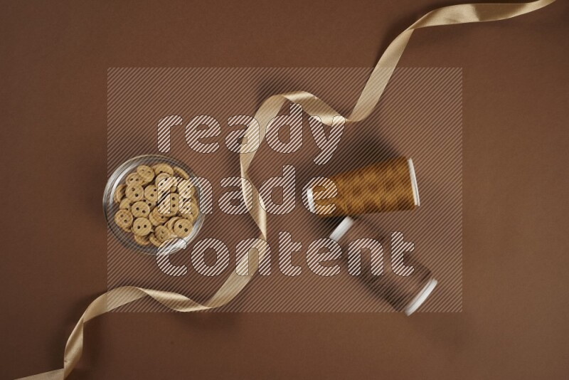 مجموعة من أدوات الخياطة والتفصيل بنية اللون على خلفية بنية