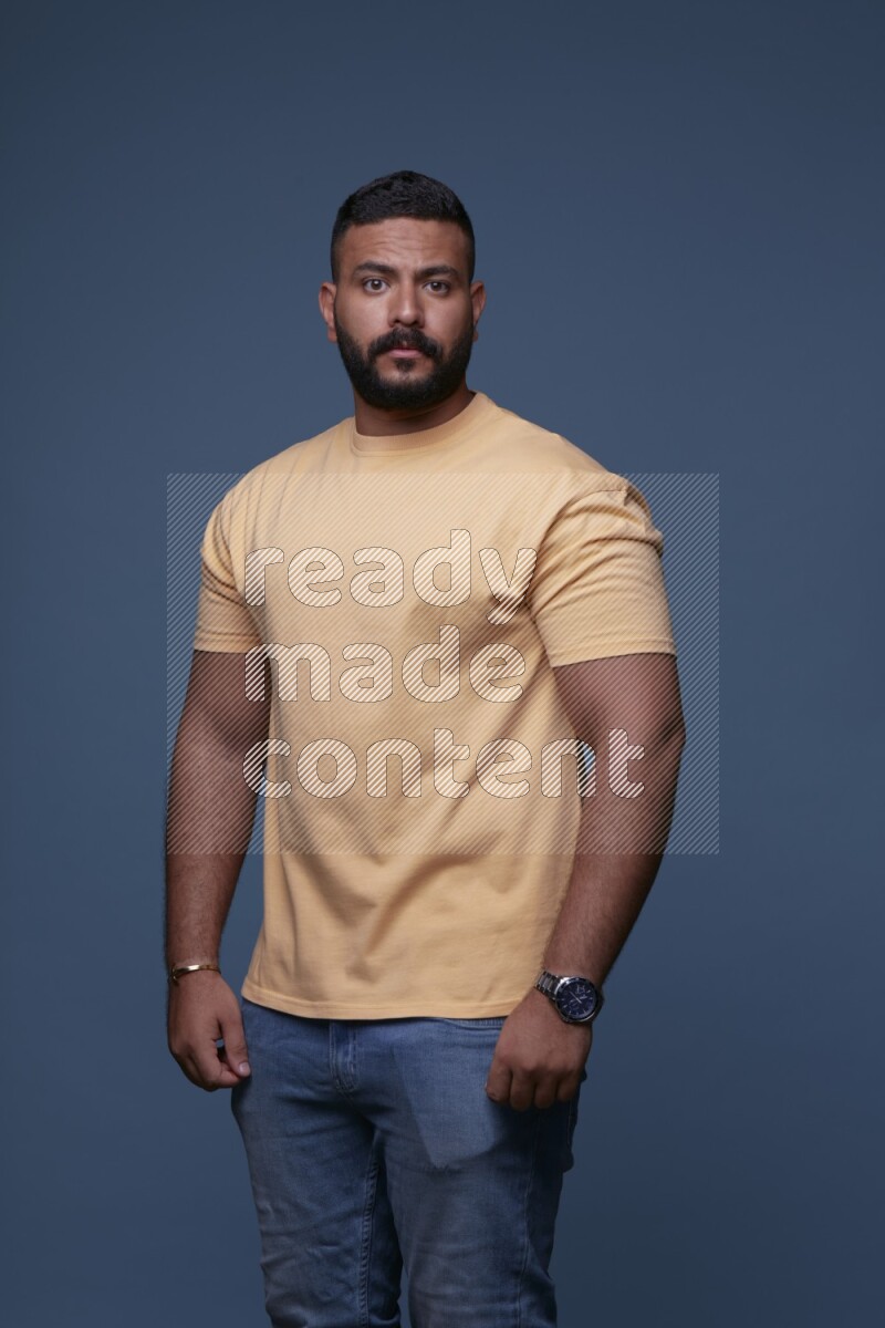 رجل يرتدي قميص اصفر بأكمام قصيرة وبنطال جينز ازرق يقف بأوضاع مختلفة