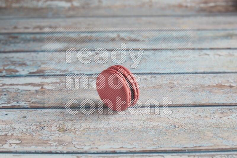 45º Shot of Pink Raspberry macaron on light blue wooden background