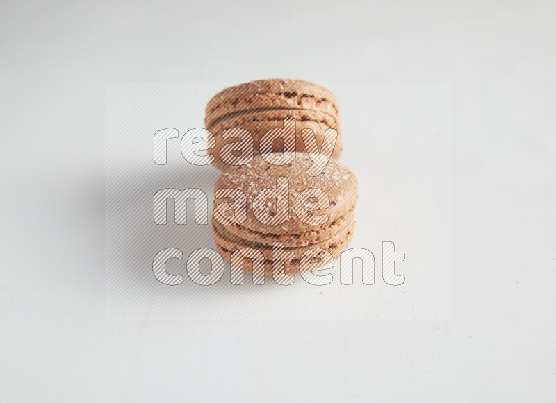 45º Shot of two Brown Hazelnuts macarons on white background
