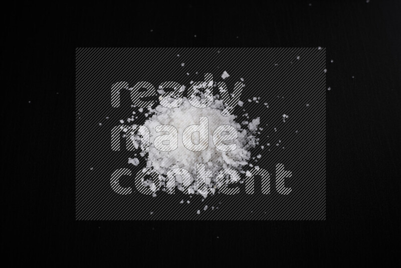 A bunch of coarse sea salt crystals on black background