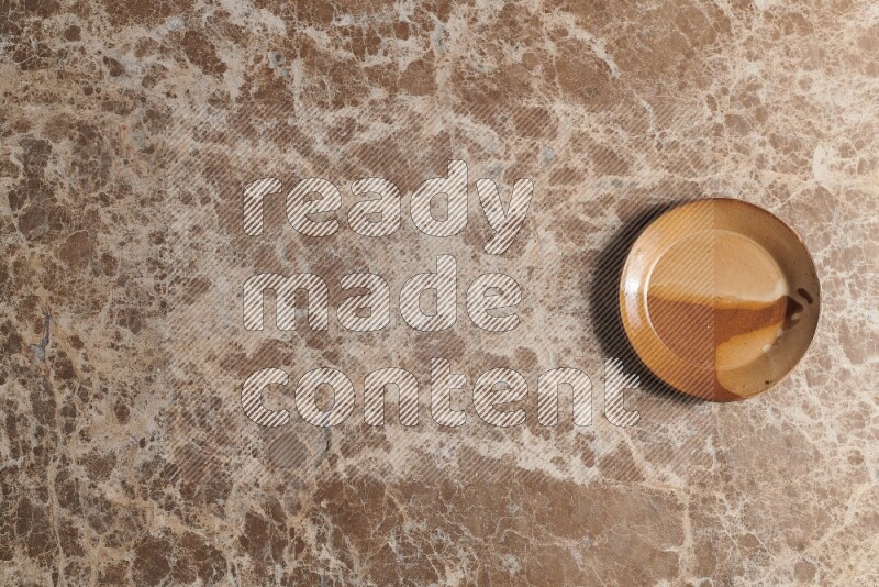 A multicolored pottery plate on beige marble background