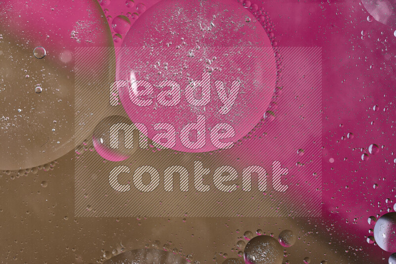 لقطات مقربة لفقاعات من الزيت على سطح الماء باللون الوردي والبني