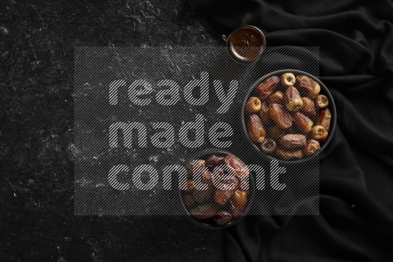 تمر في أوعية فخارية مع القهوة علي خلفية سوداء خشبية