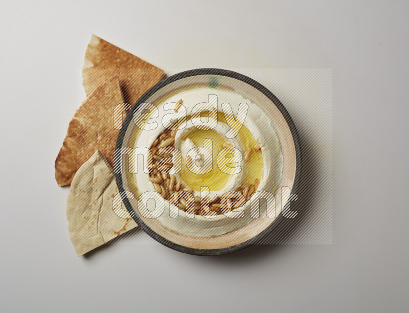 Lebnah garnished with pine nuts in a pottery plate on a white background