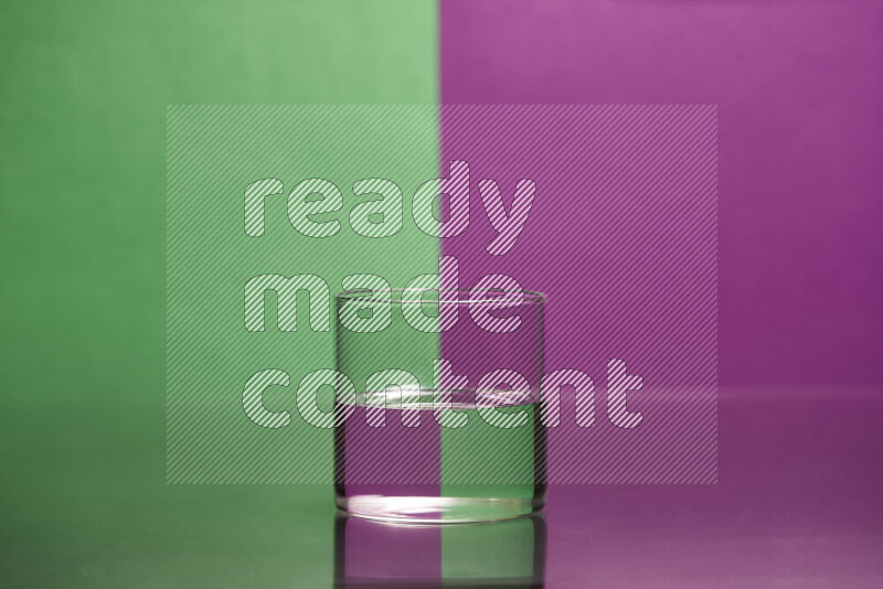 The image features a clear glassware filled with water, set against green and purple background