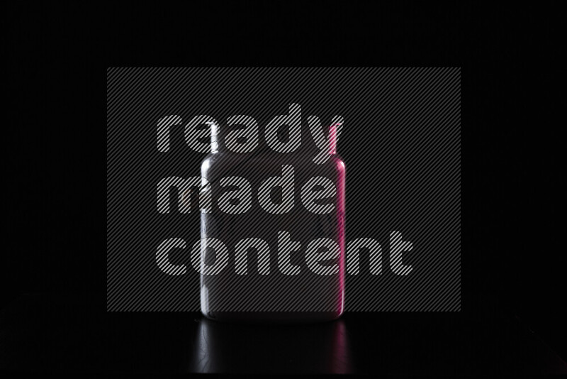 A vintage milk canister with colored rim light against black background