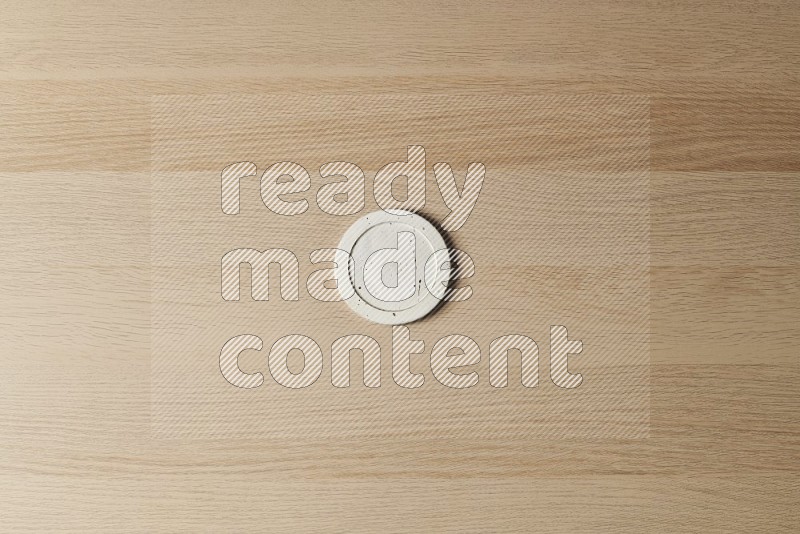 Top View Shot Of A Pottery Coaster on Oak Wooden Flooring
