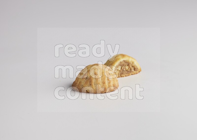 Two Pieces of Maamoul filled with walnut paste  one of them is cut direct on white background