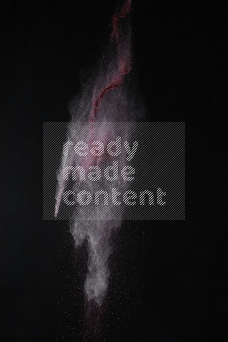 A side view of red powder explosion on black background